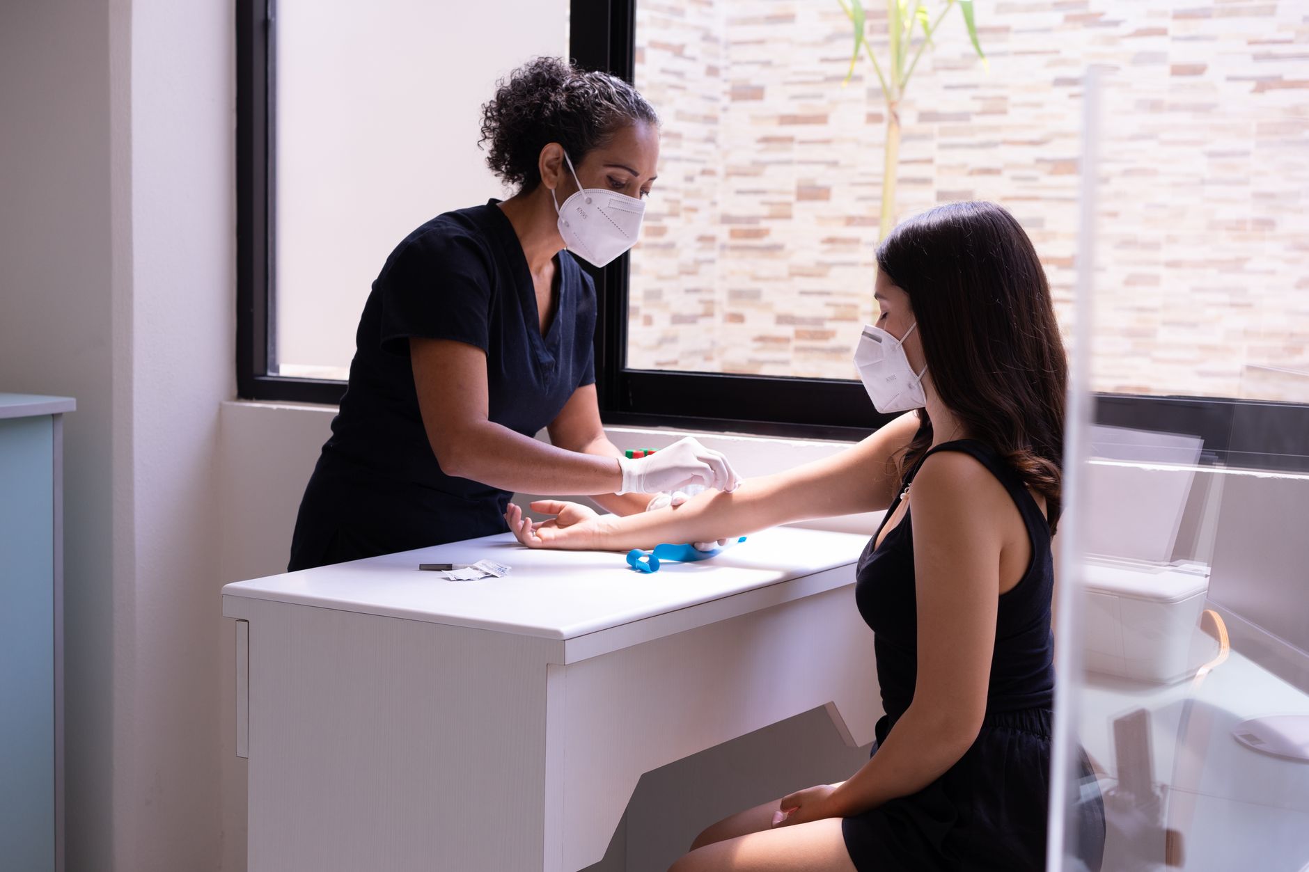 A nurse calmly taking a blood sample from a patient in a clinic — a common vasovagal syncope trigger