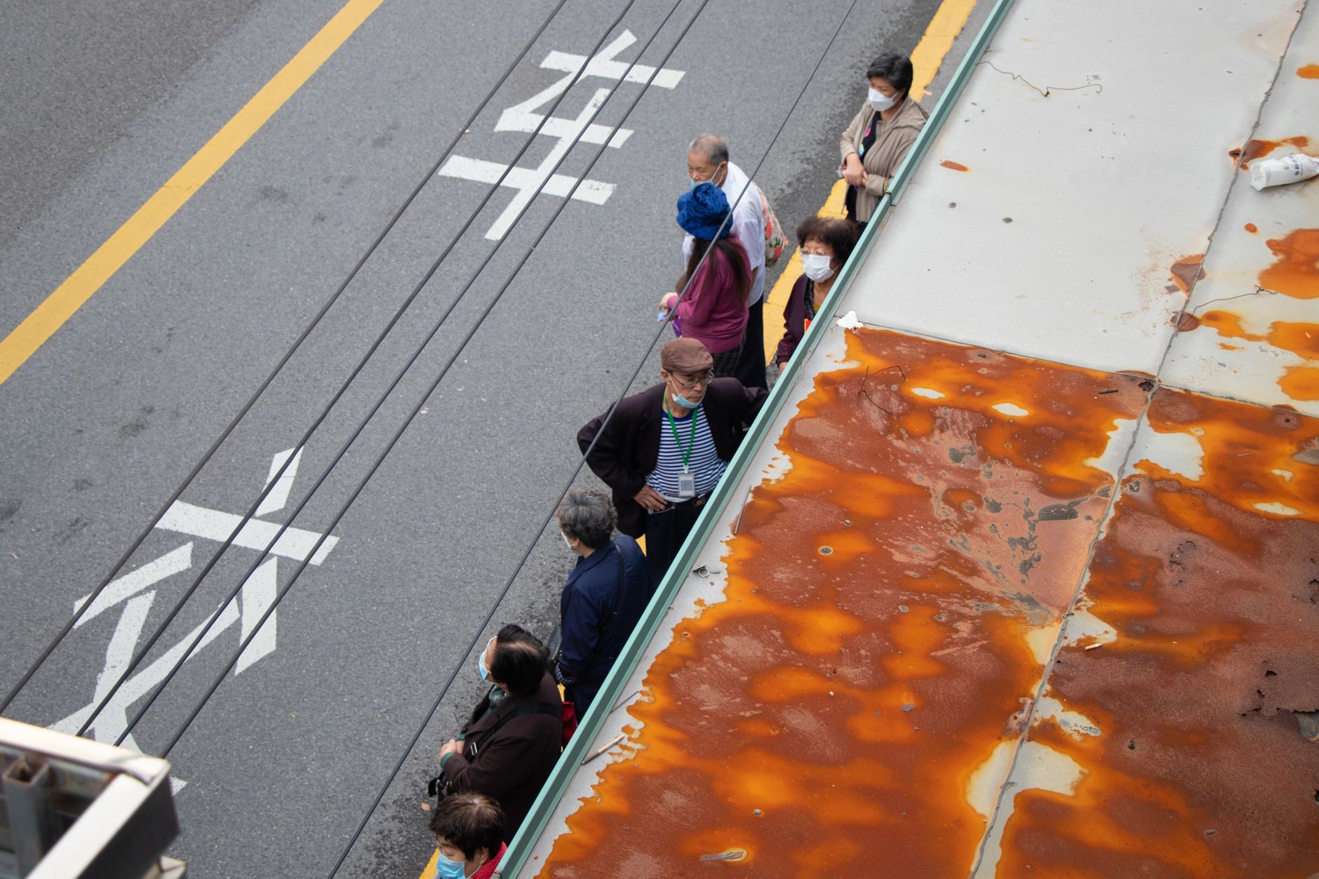 People standing in a long queue outdoors in warm weather, a known trigger for vasovagal fainting